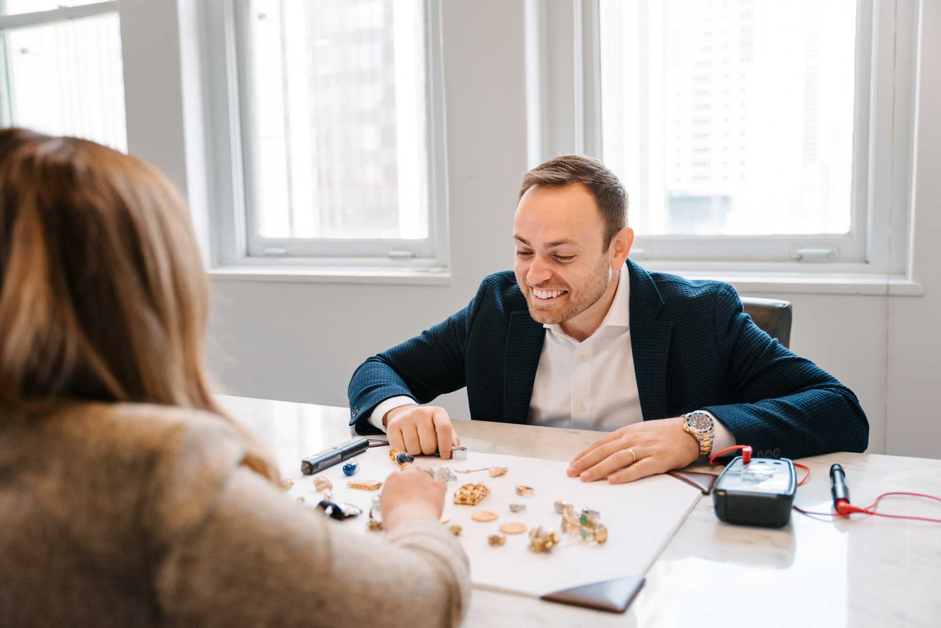 Avi at the desk with a client, Denver skyline behind