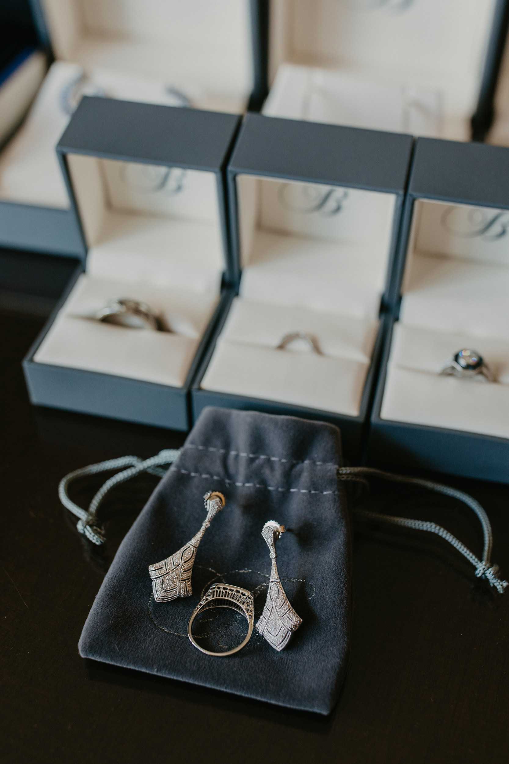Art Deco diamond drop earrings and a filigree ring on a velvet pouch